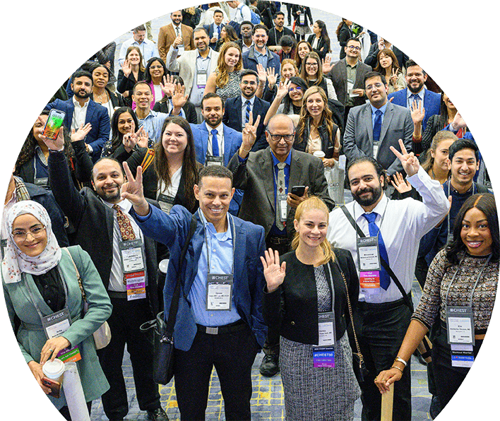 A crowd of people smile and wave during a CHEST Annual Meeting conference