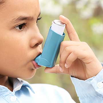 A young child uses an inhaler