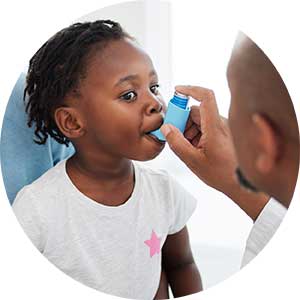 A young girl breathing into an inhaler