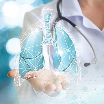 A person in white scrubs holds a graphic of lungs in their hand
