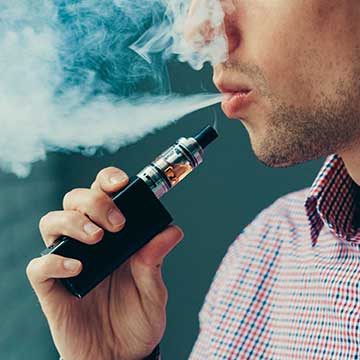 A person exhales after using an electronic cigarette