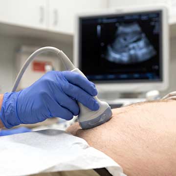 Sonographer performing abdominal ultrasound scan on a patient