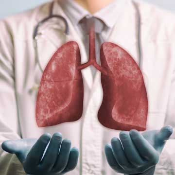 A person in a white coat and blue gloves with a lung graphic hovering over their hands